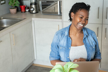 Smiling pregnant woman using laptop in kitchen