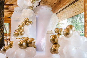Photo wall decoration space or place with white and gold balloons. Celebration baptism concept. Trendy cake. Birthday party. Birthday decorations - balloons, decor for baby party on white background.