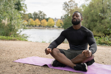 Athletic man meditating in park