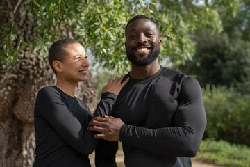 Portrait of smiling athletic couple in park