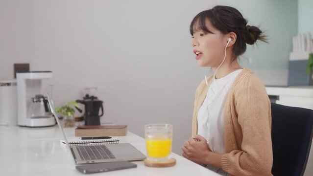 Asian woman taking via laptop video call conference remote at home