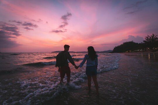Image of a couple holding hands by the sea