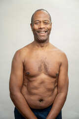 Fototapeta premium Portrait of smiling man without shirt against gray background