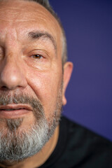 Portrait of serious man with beard against purple background