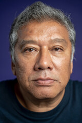 Portrait of serious man against purple background