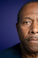 Portrait of serious man against purple background