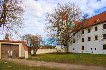 The monastery church of St Peter and Paul in the Benedictine Abbey of Thierhaupten in Bavaria on a spring day with a blue sky and changing cloud cover