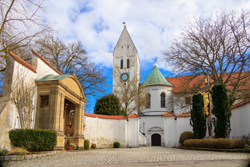 Fototapeta na wymiar The monastery church of St Peter and Paul in the Benedictine Abbey of Thierhaupten in Bavaria on a spring day with a blue sky and changing cloud cover