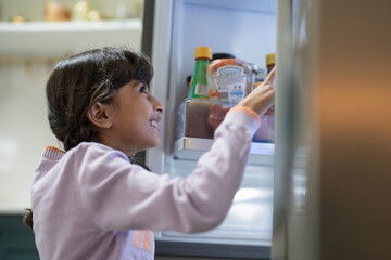 Little girl opening fridge