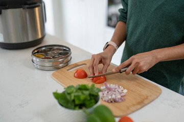 Woman cutting tomatoes on cutting board