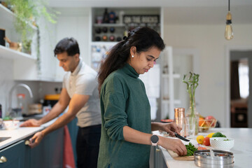 Woman and man preparing food in kitchen - obrazy, fototapety, plakaty