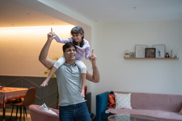 Father carrying daughter on shoulders at home - obrazy, fototapety, plakaty