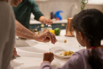 Father serving meal to daughter