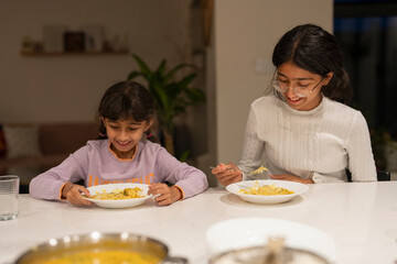 Sisters eating meal at table