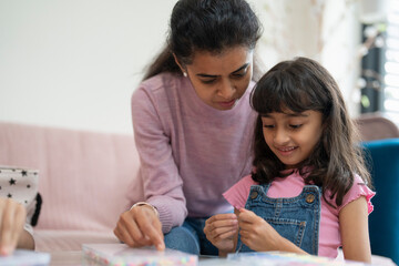 Mother with daughter playing with beads in living room