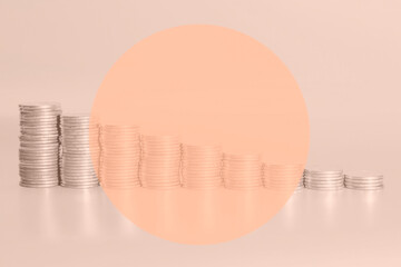 stacks of coins from largest to smallest on a peach fuzz background. decline in economy and income