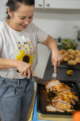 Woman slicing cooked meat on kitchen counter