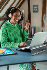 Smiling businesswoman waving during video call in office