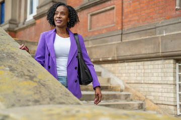 Thoughtful woman standing on steps and looking at view