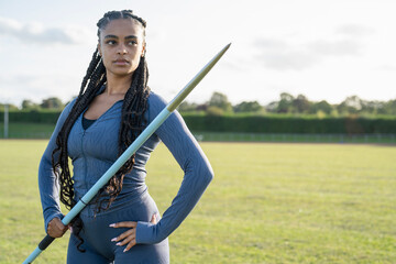Portrait of confident female athlete holding javelin