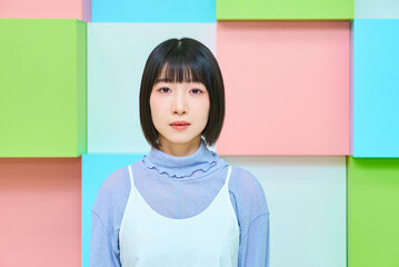 真顔の若い女性とカラフルな背景