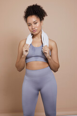 Studio portrait of athletic woman with towel around neck