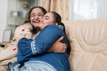 Portrait of woman embracing down syndrome granddaughter in living room