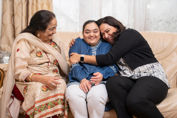 Family portrait with down syndrome woman on sofa at home