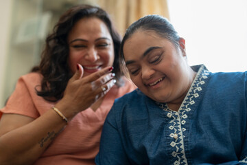 Portrait of woman with down syndrome daughter laughing at home