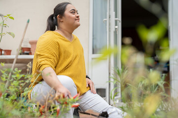 Young woman with down syndrome planting flowers in garden