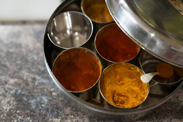 Dried spices in small bowls on kitchen counter