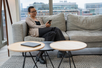 Non binary person resting in office lobby