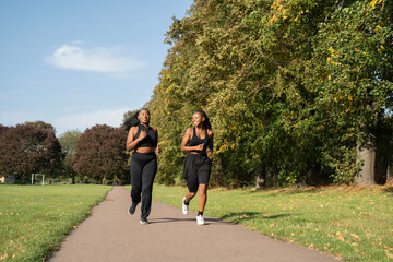 Young female friends jogging in park