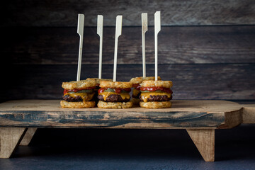 Tater beef slider skewers on a wooden serving board, ready for sharing.
