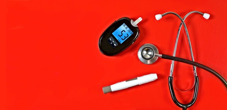 Diabetic measurement set next to stethoscope on red background. Panoramic image with copy space.