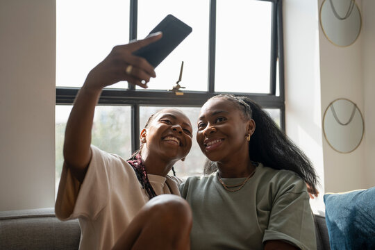 Lesbian couple taking selfie at home - Powered by Adobe