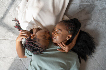 Directly above view of lesbian couple sleeping on carpet