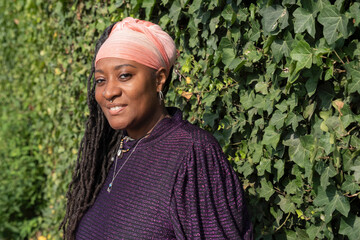 Portrait of beautiful woman with dreadlocks in front of ivy wall