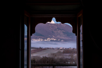 Castel di Ieri, Italy A landscape view over the Monte Sirente mountains and the Abruzzo National Park from an open window in a cottage at dusk.