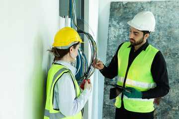 team electrical engineers or technicians is professionally inspecting the wiring and systems in the building. Check electrical equipment to meet safety standards. Use a tablet to check buildings.