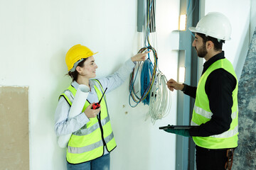 team electrical engineers or technicians is professionally inspecting the wiring and systems in the building. Check electrical equipment to meet safety standards. Use a tablet to check buildings.