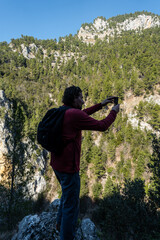 Raiano, Italy A male hiker tkes a photo with a phne in the Gole di san Venanzio canyon.