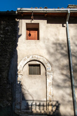 Pacentro, Italy A sun-drenched arch on the facade of an old building.