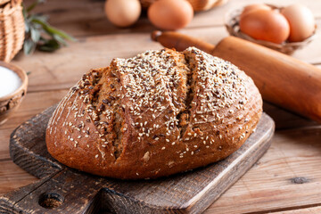 Protein bread (without flour) with linseeds, sunflower seeds and sesame seeds on cutting board. Selective focus.