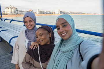Fototapeta na wymiar Portrait of three Muslim women standing on pier
