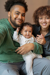 Smiling parents with baby daughter at home
