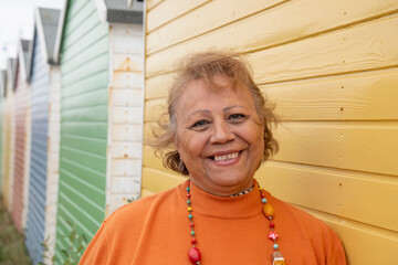 Portrait of smiling senior woman standing by beach hut