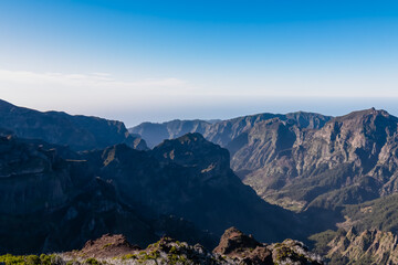 Scenic view of mountain ridges and majestic canyon of rugged terrain on Madeira island, Portugal, Europe. Idyllic hiking trail to mountain peak Pico Ruivo. Coastal landscape on sunny day. Tranquility