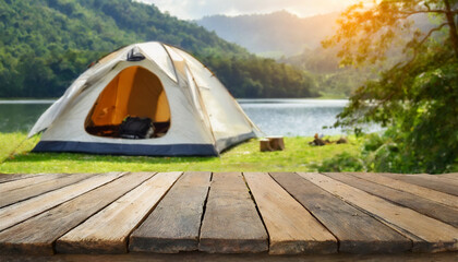 Wooden table in blurred camping tent and mountain on a beautiful sunny day. Cool and relaxing concept. For product display montage or key visual layout design. space for text