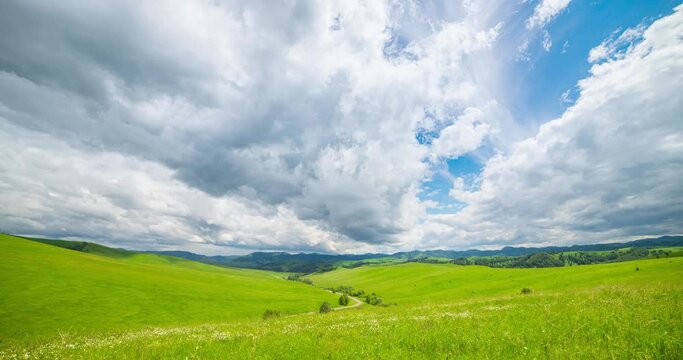 Mountain meadow time-lapse at the summer or autumn time. Wild nature and rural field. Fast clouds movement, green grass and sun rays. Motorised panorama